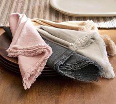 four folded towels sitting on top of wooden plates