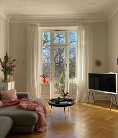 a living room filled with furniture and a flat screen tv sitting on top of a hard wood floor