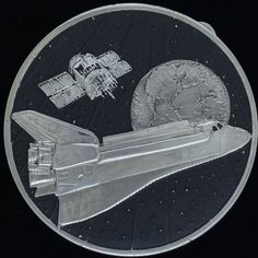 a silver plate with an image of a space shuttle on it's back side