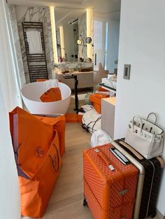 several pieces of luggage sitting on the floor in front of a bathtub and sink