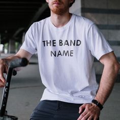 a man sitting on a scooter wearing a band name t - shirt