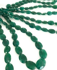 green faceted glass beads on a white background