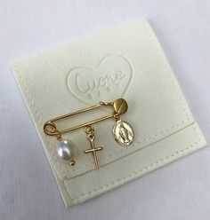 Our 24K gold plated baby safety pin has 3 charms: a gold plated cross, a gold plated virgin (milagrosa), and a natural pearl. It makes the perfect baby shower, new born, and christening gift. You will receive your safety pin in this beautiful pouch to store and carry it safetly. For safety reasons please do not leave the baby unattended while wearing the pin. If you want to choose your own charms please write to me. Gold Safety Pin Shaped Jewelry With Charms, Personalized Gold Pins For Gifts, Gold Safety Pin Jewelry For Wedding, Gold Safety Pin Shaped Brooch, Gold Safety Pin Shaped Brooch Jewelry, Handmade Gold Jewelry For Baptism, Perfect Baby Shower, Gold Baby, Christening Gifts