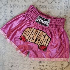 a pink boxing shorts with the word hawaii painted on it