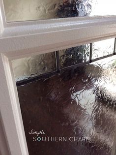 an open door with the reflection of water on it's glass and window sill