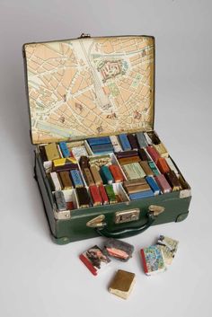 an open suitcase filled with lots of different types of items on top of a white surface