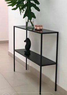 a plant is sitting on top of a black shelf