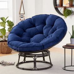 a blue chair sitting on top of a metal stand next to a potted plant