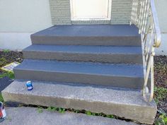 the steps lead up to an apartment building with a blue can on the ground next to it