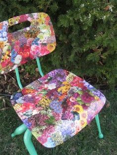 two chairs sitting in the grass with flowers on them and one has a green frame