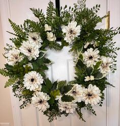 a wreath with white flowers and green leaves