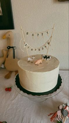 a birthday cake sitting on top of a white tablecloth covered table with toys and decorations