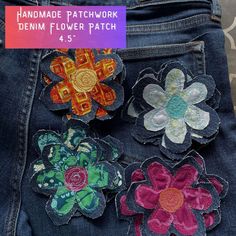 three flower appliques are placed on the back of a pair of denim jeans