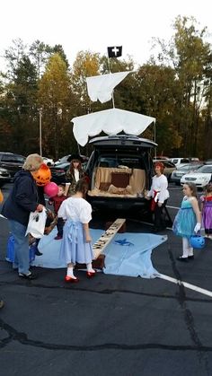 children are lined up in front of the trunk of a car that has been decorated for halloween