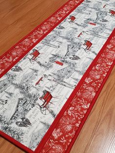 a red and white table runner on a wooden floor