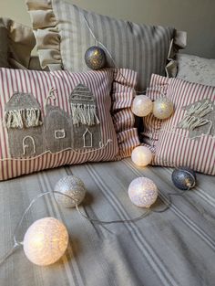 decorative pillows and string lights on a bed