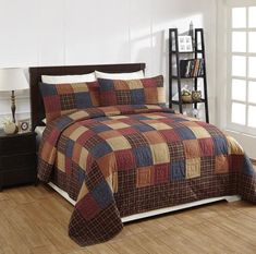 a bed with a brown and blue checkered comforter set on top of it