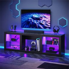 the entertainment center is lit up with purple lighting and gaming accessories on it's shelves