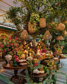 an image of a flower shop with flowers in baskets on the ceiling and lights hanging from the ceiling