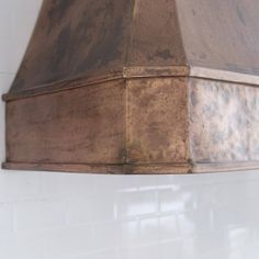 an old copper stove hood hanging on the wall