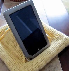 an electronic device sitting on top of a yellow blanket