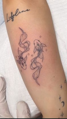 a woman's arm with two fish on it and the word life written in cursive writing