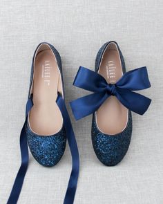 a pair of blue glitter shoes with a bow