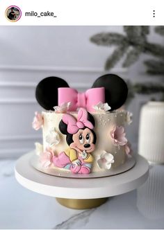 a minnie mouse cake with pink bows on top