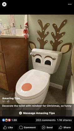 a bathroom decorated for christmas with reindeer decorations on the wall and toilet seat cover,