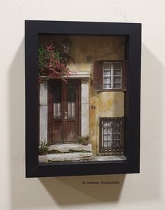 an old photo hanging on the wall in front of a door and window with shutters