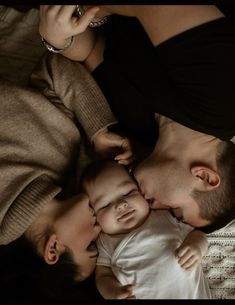 a man laying on top of a bed next to two babys with their mouths open