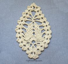 a crocheted doily is shown on a blue surface