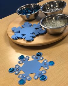 three bowls and one bowl are sitting on a table with snowflakes in them