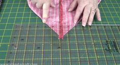 an older woman is cutting fabric on a table with scissors and a pair of scissors