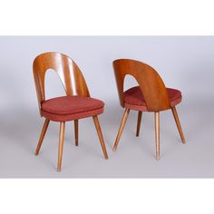 two wooden chairs with red upholstered cushions