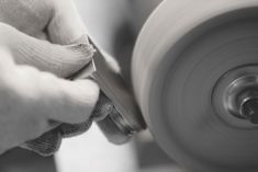 a person using a grinder to make something out of paper on a machine wheel