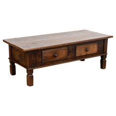 an old wooden coffee table with two drawers on one side and three drawers on the other