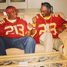 two football players sitting on a couch together