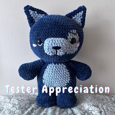 a blue crocheted teddy bear sitting on top of a bed with the words tester appreciation written below it