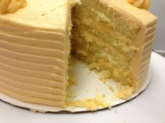 a white cake with yellow frosting on a plate