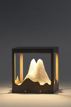 a light that is sitting on top of a wooden box with mountains in the background