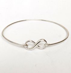 "This is a small sized dainty & delicate sterling infinity which I transform into an infinity bangle bracelet with sterling silver bangle band. PURITY OF METAL: This makes a great gift for teen girls since all elements of the bracelet are sterling silver. Sterling silver is suggested for teen girl jewelry because of the purity of the metal. It's great for adults too. PERSONALIZED OPTIONS: Select optional initial charms (up to 3) to dangle from the infinity loop. I can also add charms to the Minimalist Sterling Silver Bracelets For Bridesmaids, Hypoallergenic Sterling Silver Infinity Jewelry, Hypoallergenic Infinity Sterling Silver Jewelry, Sterling Silver Bracelet For Bridesmaids, Minimalist Silver Infinity Bracelet, Adjustable Sterling Silver Bracelet For Mother's Day, Sterling Silver Infinity Bracelets For Everyday, Sterling Silver Infinity Bracelet For Everyday, Adjustable Infinity Jewelry For Bridesmaid Gift