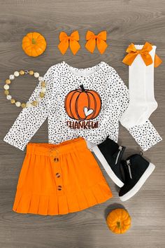 Perfect for Fall & Thanksgiving time Top features long sleeves and a "Thankful" pumpkin design Skirt features stretch waist & decorative buttons Top and skirt pair for versatility & ease Your little one will look oh-so adorable in our "Thankful" White & Orange Pumpkin Skirt Set for girls. The polka dot long sleeve top features a pumpkin design on the front and looks adorable paired with the orange skirt. The stretch waistband helps comfort and fit and can be great for on the go, while the matchi Pumpkin Skirt, Harvest Festivals, Thankful Pumpkin, Boutique Outfits, Thanksgiving Time, Sparkle In Pink, Design Skirt, Fall Baby Clothes, Girls Fall Outfits