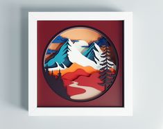 a paper cut landscape with trees and mountains in the background is mounted on a wall