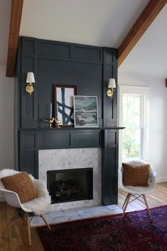 a living room with a fireplace and two chairs in front of the fire place that is painted dark green