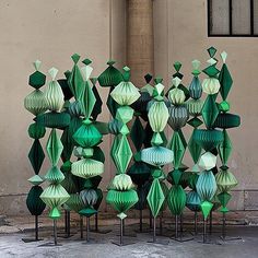 a group of green sculptures sitting in front of a building