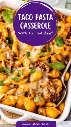 taco pasta casserole with ground beef and cheese in a white baking dish