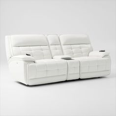 a white leather reclining sofa with two seats on it's back and one arm facing the camera