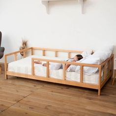 a woman laying on top of a bed next to a chair