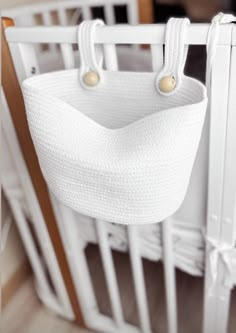 a crib with a white bag hanging from it's side